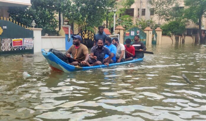 People use a boat to shift to a safer place from a flooded area